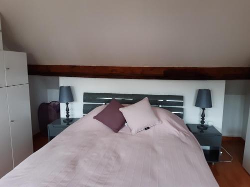 ein Schlafzimmer mit einem Bett mit zwei Tischen und zwei Lampen in der Unterkunft Ravissante suite.chambre d hôte in Saint-Valéry-en-Caux