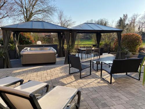 a gazebo with tables and chairs and a grill at Les Rives des Habsbourg in Ensisheim