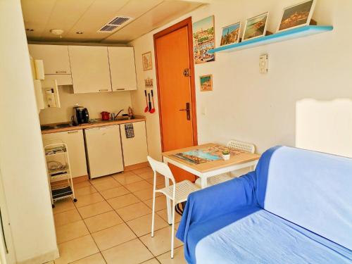 Cette chambre comprend une cuisine, une table et un lit. dans l'établissement MENTON BORD DE MER Studio calme avec balcon, Ascenseur, Climatisation, Ideal location quiet near sea, balcony, elevator, AC, à Menton