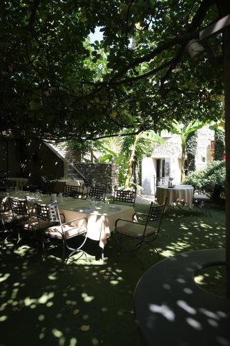 a group of tables and chairs under a tree at Le Castellas Hotel & SPA - TERITORIA in Collias