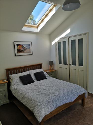 a bedroom with a bed and a skylight at Barn Owl in Happisburgh