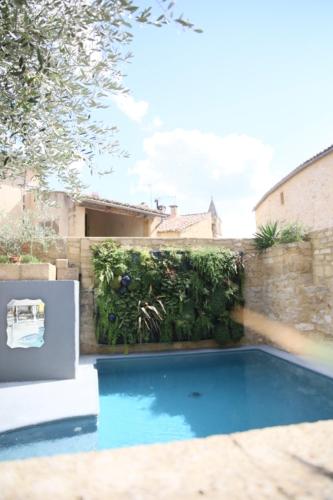 a swimming pool with blue water in a yard at Le Castellas Hotel & SPA - TERITORIA in Collias