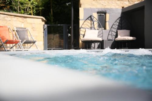 a pool of water with chairs and a house at Le Castellas Hotel & SPA - TERITORIA in Collias