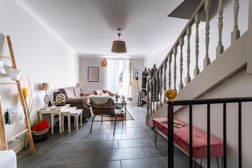 a living room with a couch and a staircase at La Maison Rose in Grignan