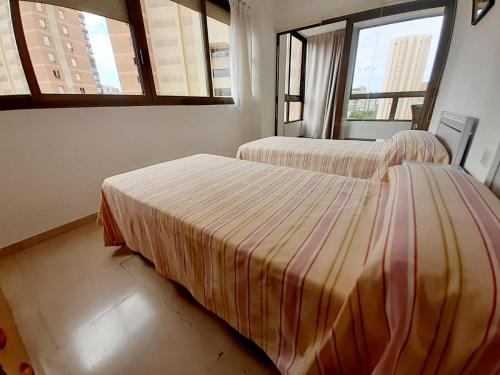 2 camas en una habitación con 2 ventanas en gemelos 4 playa levante, en Benidorm