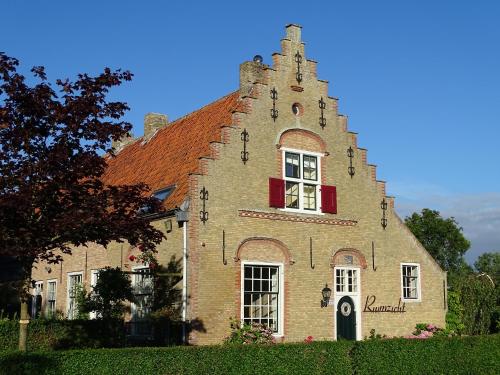 a large brick building with a tower on top of it at Hoeve Ruimzicht Renesse in Renesse