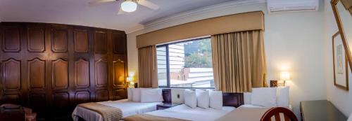 a hotel room with two beds and a window at Best Western Plus Hotel Stofella in Guatemala