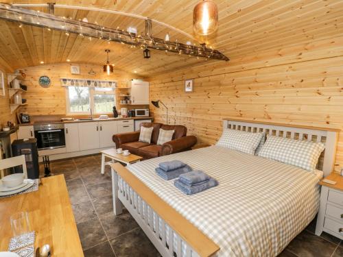 a bedroom with a bed in a log cabin at Robins Nest in Southam