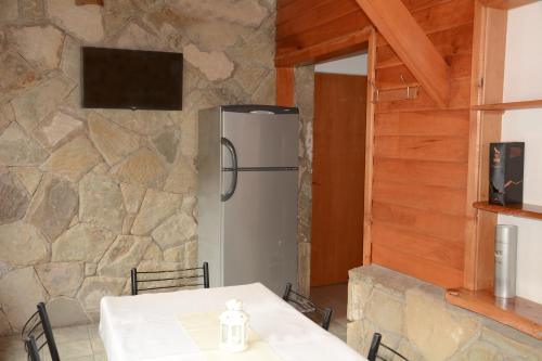 uma cozinha com uma mesa e um frigorífico em Apart Hotel del Pellin em San Martín de los Andes