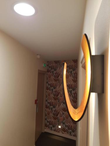 a mirror hanging on a wall in a room at Les Chants d'Ailes - Hôtel Face Mer in La Turballe