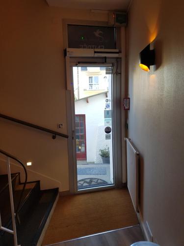 a hallway with a door leading to a stairway at Les Chants d'Ailes - Hôtel Face Mer in La Turballe