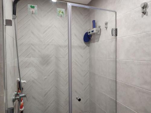 una ducha con puerta de cristal en un baño en L'Orchidée de Kénitra, en Kenitra