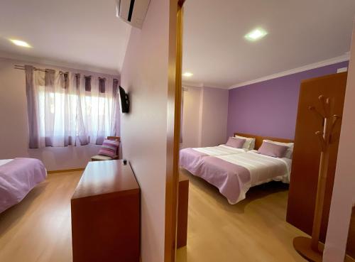 a room with two beds and a window at Hotel Hebe Peniche in Peniche