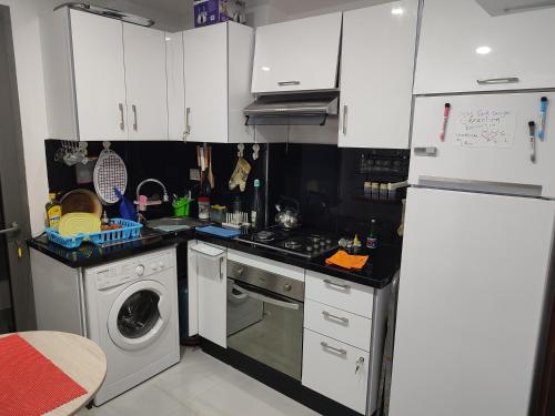 a kitchen with white cabinets and a washing machine at L'Orchidée de Kénitra in Kenitra