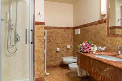 W łazience znajduje się toaleta, umywalka i prysznic. w obiekcie Hotel Roxy Plaza w mieście Soave