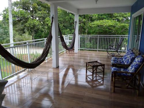 a porch with a hammock and chairs on a balcony at Paraíso dos Accácio in Balneario Barra do Sul