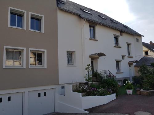 a white house with some plants in front of it at Les Chants d'Ailes - Hôtel Face Mer in La Turballe