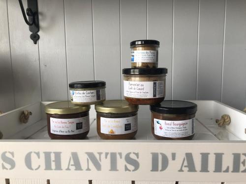 four jars of food sitting on a shelf at Les Chants d'Ailes - Hôtel Face Mer in La Turballe