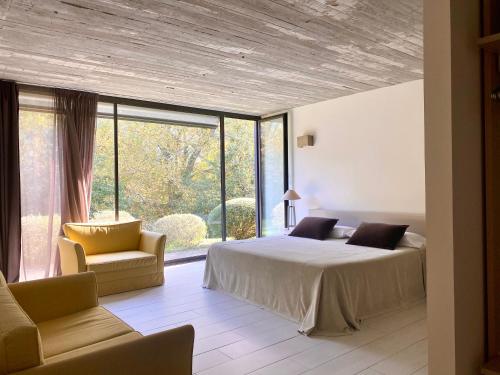 a bedroom with a bed and a large window at CAEaCLAVELES in La Pereda de Llanes