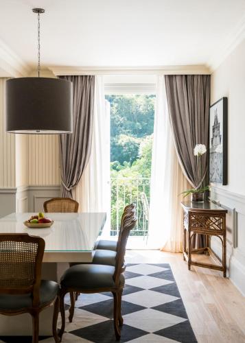 a dining room with a table and chairs and a large window at Palácio Tangará, Oetker Hotels in Sao Paulo