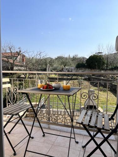 a table with a bowl of fruit on a balcony at Apartment Lorun 47 in Tar