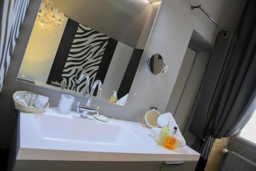 a bathroom with a sink and a mirror at Le Castellas Hotel & SPA - TERITORIA in Collias