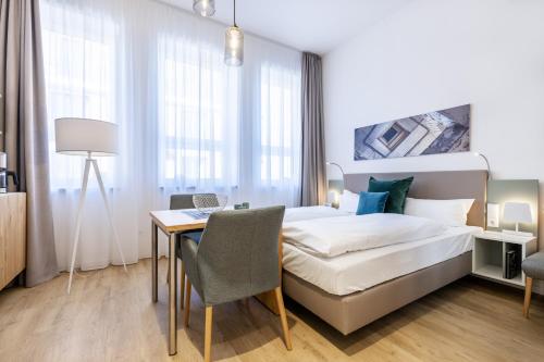 1 dormitorio con cama, escritorio y mesa en Ferienapartments am Krusespeicher Ferienapartments am Krusespeicher 3-28 en Wismar