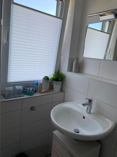 a white bathroom with a sink and a window at Haus am Wasserturm Gästezimmer in Schorndorf-Schlichten in Schorndorf