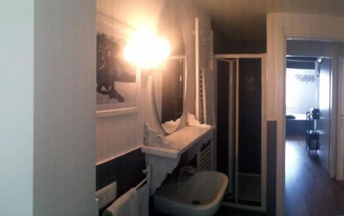 a bathroom with a sink and a light on the wall at Il Fonticolo Room & Breakfast in Modena