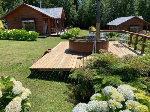 a wooden deck with a hot tub in a yard at Cabañas Copayapu in Pucón