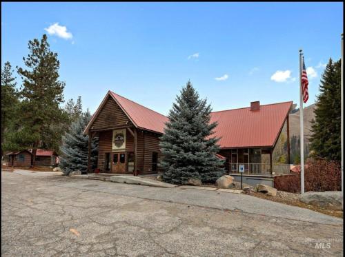 a log cabin with a red roof on a street at Southfork Lodge Cabin 2 in Lowman