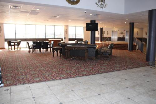 Apm Inn & Suites في هاجرستاون: غرفة كبيرة فيها بيانو وطاولات وكراسي