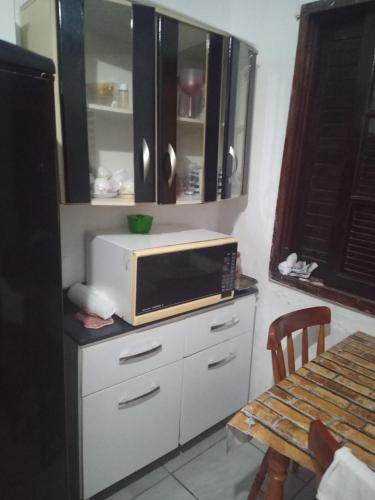 a microwave on top of a counter in a kitchen at Mongaguá House in Mongaguá