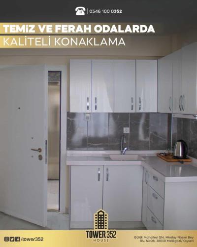 a kitchen with white cabinets and a sign that reads temp iv fürüradi at Tower352 in Melikgazi