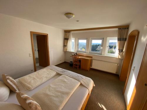 ein Schlafzimmer mit 2 Betten und einem Schreibtisch. in der Unterkunft Berghotel Lenneplätze Winterberg in Winterberg