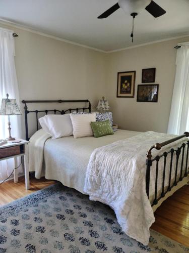 um quarto com uma cama grande e uma ventoinha de tecto em Benjamin F. Packard House Bed and Breakfast em Bath