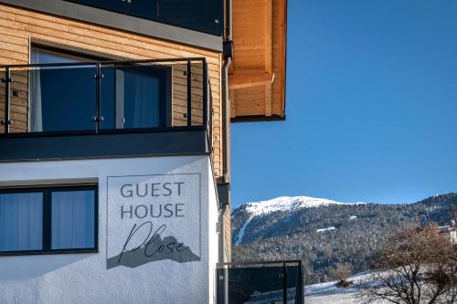 a guest house sign on the side of a building at Guesthouse Plose in Bressanone