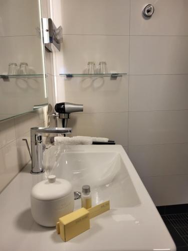La salle de bains est pourvue d'un lavabo blanc et de toilettes. dans l'établissement Hotel Restaurant Alte Stadtmauer, à Beilstein