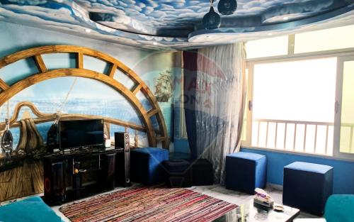 un soggiorno con soffitti decorati e una grande finestra di شقة فخمة فيوالبحر Luxury Panorama Sea View ad Alessandria d'Egitto