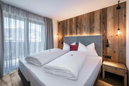 a bedroom with a large white bed with white pillows at Guesthouse Plose in Bressanone
