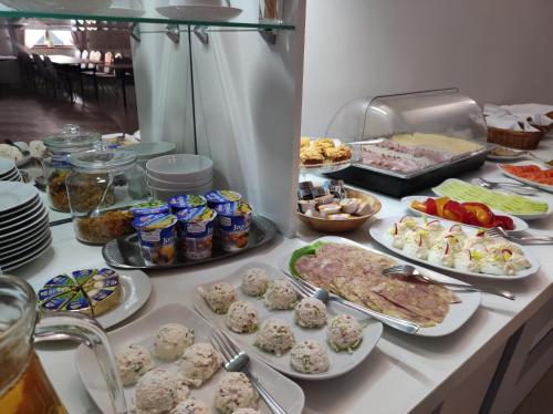 un buffet avec de nombreux types de nourriture sur une table dans l'établissement Pensjonat Wioletta, à Ostrołęka