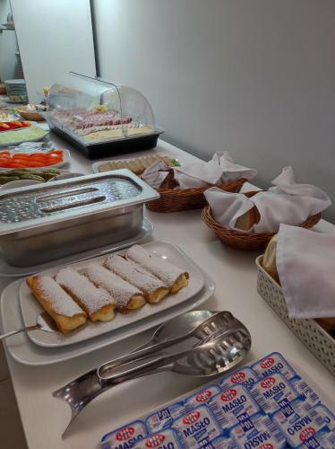 een tafel met dienbladen met voedsel en andere voedingsmiddelen bij Pensjonat Wioletta in Ostrołęka