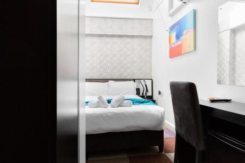 a bedroom with a bed with two towels on it at Central Hoxton Shoreditch in London