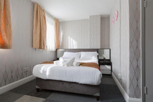 a bedroom with a large bed with white sheets and pillows at Central Hoxton Shoreditch in London