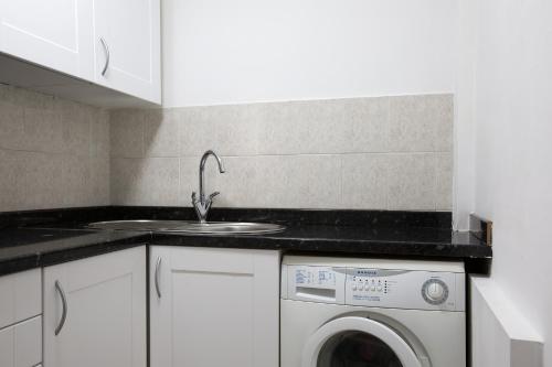 a kitchen with a sink and a washing machine at Central Hoxton Shoreditch in London