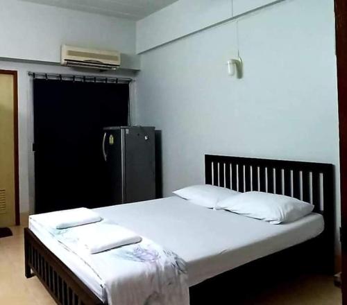 ein Bett mit zwei Kissen auf einem Zimmer in der Unterkunft Jirapong apartment in Bangkok