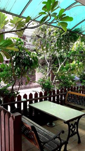 einem grünen Tisch und einer Bank in einem Gewächshaus in der Unterkunft Jirapong apartment in Bangkok