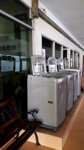 a row of washers and dryers in a building at Jirapong apartment in Bangkok