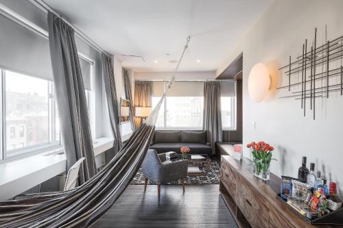 a living room with a wooden floor and a large window at NU Hotel in Brooklyn