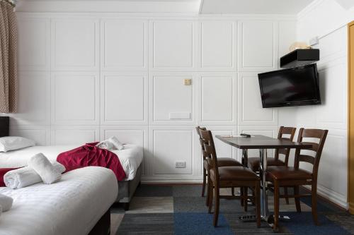 a room with a table and chairs and a tv at Central Hoxton Shoreditch in London